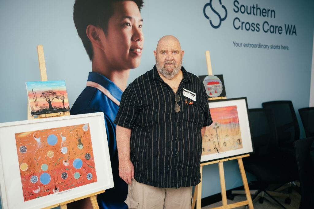 Andy Ryan showing his paintings during NAIDOC week